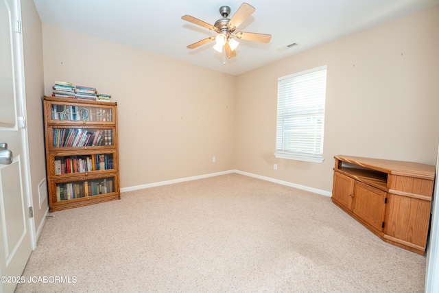 unfurnished room featuring baseboards, light carpet, visible vents, and ceiling fan