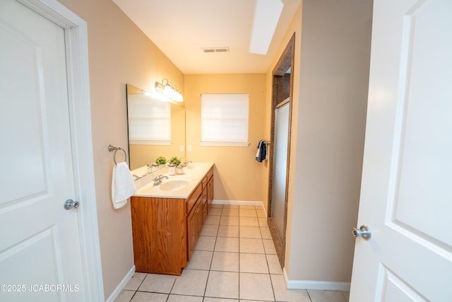 bathroom featuring visible vents, double vanity, a sink, tile patterned floors, and a shower with door