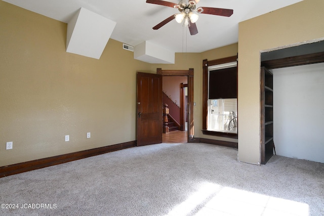 unfurnished bedroom featuring ceiling fan, light carpet, and a closet