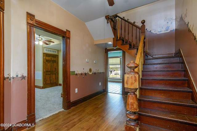 stairway with hardwood / wood-style floors, vaulted ceiling, and ceiling fan