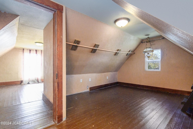 bonus room with hardwood / wood-style flooring and vaulted ceiling