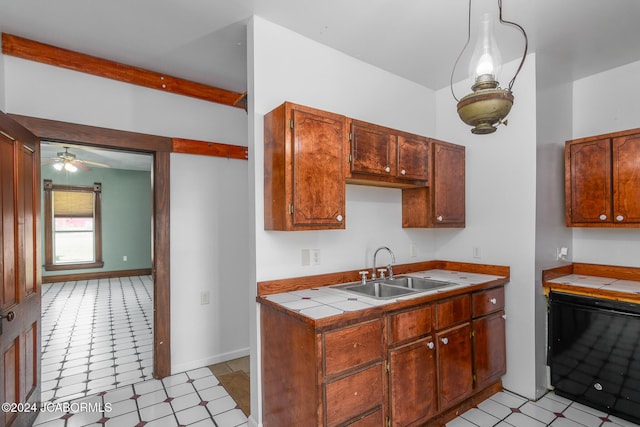 kitchen with ceiling fan, sink, beamed ceiling, tile countertops, and decorative light fixtures