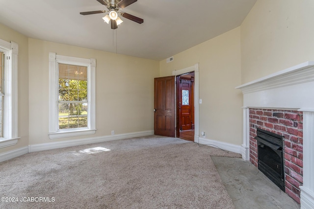 unfurnished living room with ceiling fan, light colored carpet, and a brick fireplace