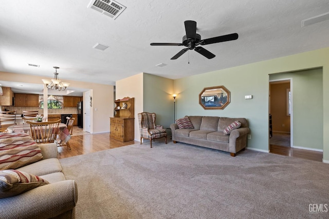3113 Raccoon Dr, Lake Isabella, CA 93240 - living room featuring light carpet, a chandelier, a ceiling fan, and baseboards