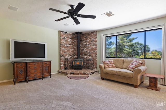 3113 Raccoon Dr, Lake Isabella, CA 93240 - living room with carpet flooring, a wood stove, ceiling fan, and baseboards