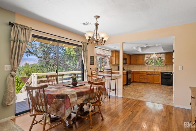 3113 Raccoon Dr, Lake Isabella, CA 93240 - dining space featuring light wood-style flooring, a raised ceiling, a chandelier, and baseboards