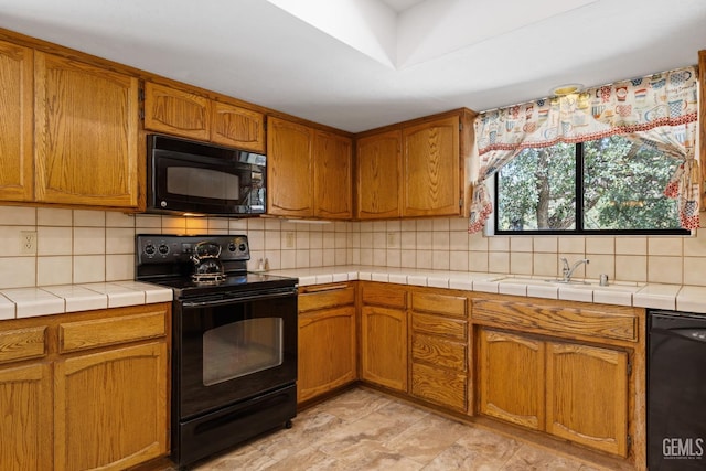 3113 Raccoon Dr, Lake Isabella, CA 93240 - kitchen with black appliances, backsplash, tile counters, and brown cabinetry