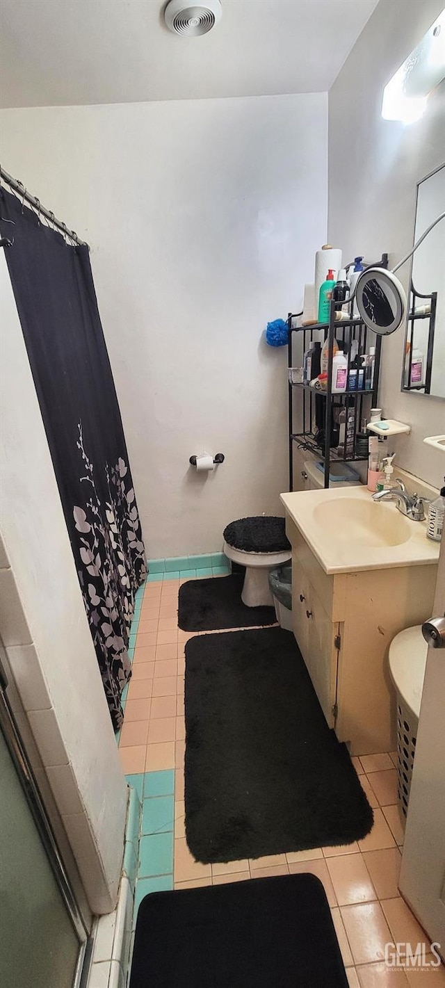 bathroom featuring tile patterned floors, curtained shower, vanity, and toilet