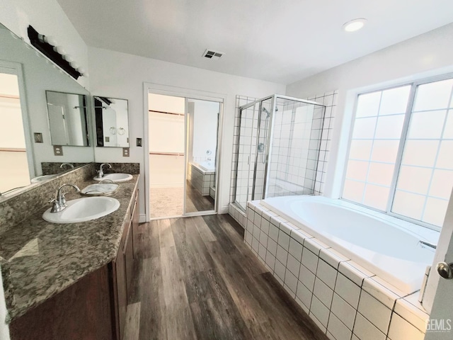 7205 Colony Park Dr, Bakersfield, CA 93313 - full bath with wood finished floors, a shower stall, a garden tub, double vanity, and a walk in closet