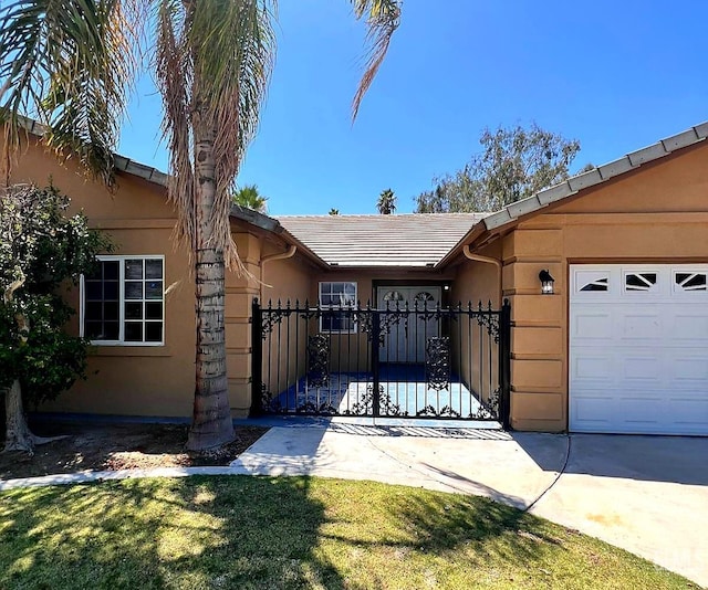 7205 Colony Park Dr, Bakersfield, CA 93313 - view of front of property featuring stucco siding, a tiled roof, a garage, and a gate