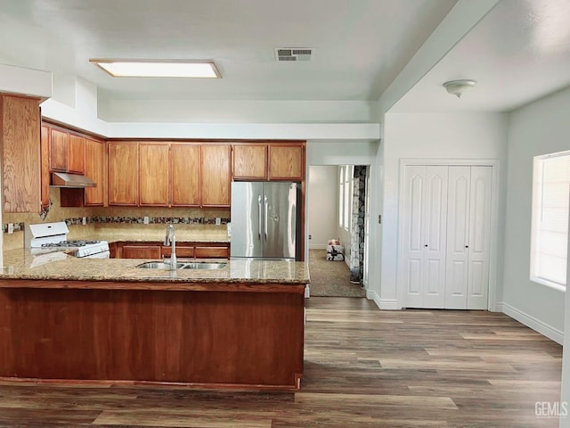 7205 Colony Park Dr, Bakersfield, CA 93313 - kitchen with freestanding refrigerator, gas range gas stove, under cabinet range hood, a peninsula, and dark wood-type flooring