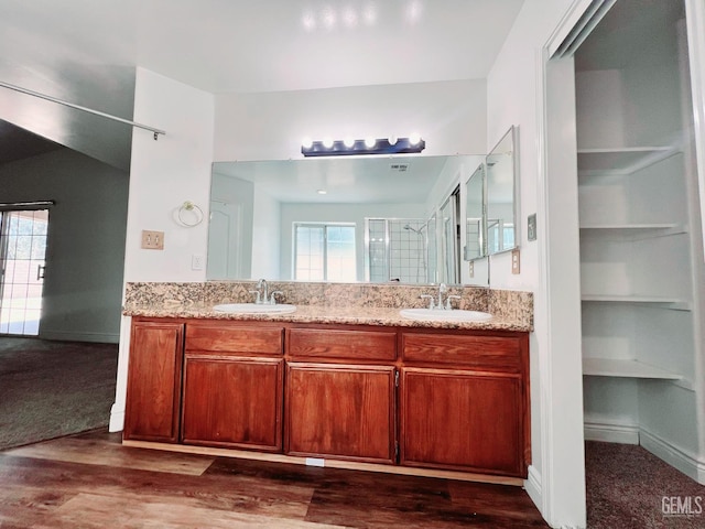 7205 Colony Park Dr, Bakersfield, CA 93313 - full bathroom featuring double vanity, a shower with shower door, wood finished floors, and built in shelves