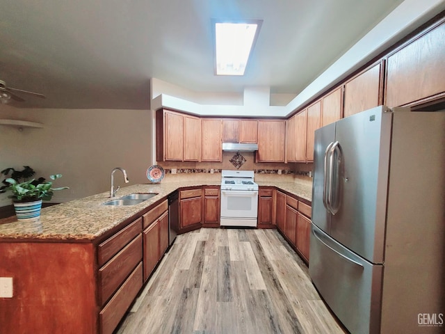 7205 Colony Park Dr, Bakersfield, CA 93313 - kitchen featuring appliances with stainless steel finishes, under cabinet range hood, light wood-style floors, a peninsula, and light stone counters