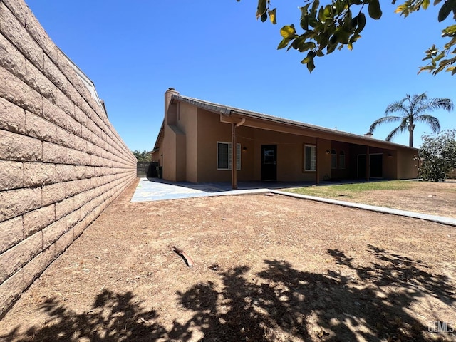 7205 Colony Park Dr, Bakersfield, CA 93313 - rear view of house featuring stucco siding, a patio area, and a chimney