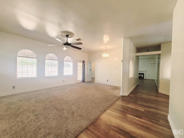 7205 Colony Park Dr, Bakersfield, CA 93313 - unfurnished room featuring a ceiling fan, a chandelier, wood finished floors, and a fireplace