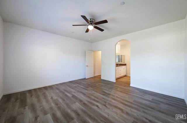 8412 Jean Anne St, Bakersfield, CA 93314 - unfurnished bedroom with dark wood-type flooring, arched walkways, ensuite bath, and ceiling fan