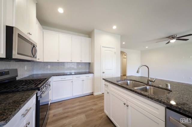 8412 Jean Anne St, Bakersfield, CA 93314 - kitchen featuring stainless steel appliances, arched walkways, light wood finished floors, backsplash, and ceiling fan