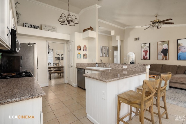 kitchen with a kitchen bar, kitchen peninsula, pendant lighting, stainless steel appliances, and white cabinets