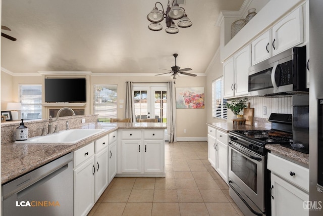 kitchen with appliances with stainless steel finishes, white cabinetry, sink, ornamental molding, and ceiling fan