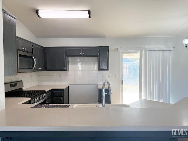 5717 Arc Dome Ave, Bakersfield, CA 93313 - kitchen with stainless steel appliances, decorative backsplash, light countertops, and dark cabinets