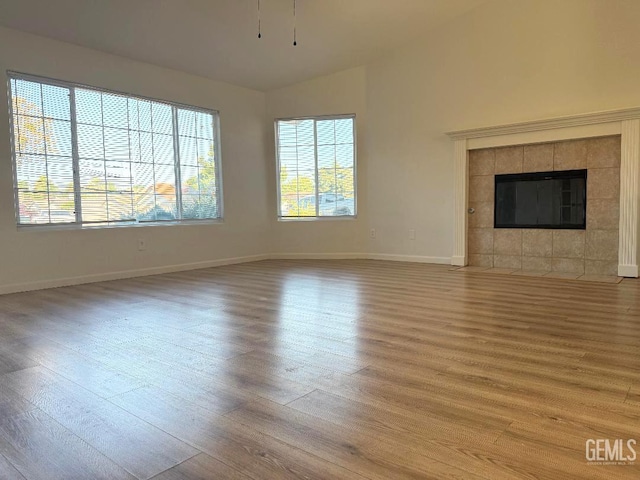 5717 Arc Dome Ave, Bakersfield, CA 93313 - unfurnished living room with wood finished floors, vaulted ceiling, and a fireplace