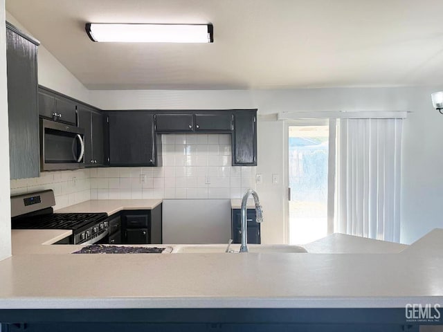 5717 Arc Dome Ave, Bakersfield, CA 93313 - kitchen with appliances with stainless steel finishes, tasteful backsplash, dark cabinets, and light countertops