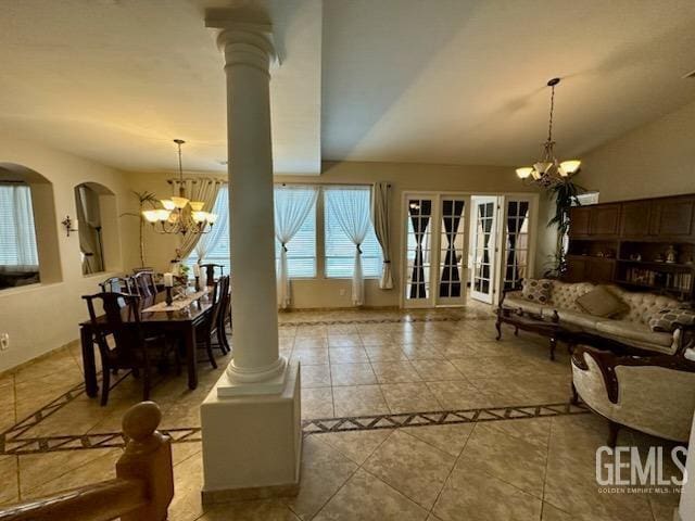 interior space featuring arched walkways, a notable chandelier, lofted ceiling, and decorative columns