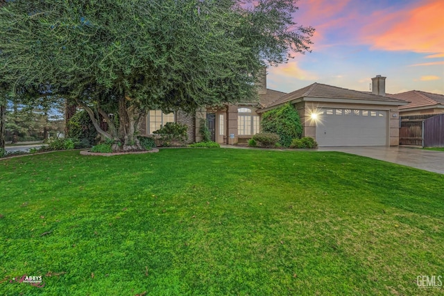 view of front of home featuring a garage and a yard