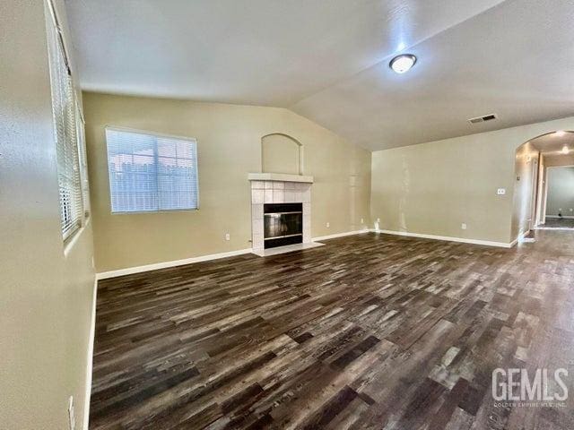 unfurnished living room with a fireplace, dark hardwood / wood-style floors, and vaulted ceiling