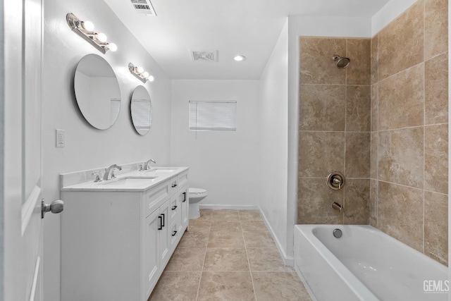 full bathroom featuring tiled shower / bath, vanity, toilet, and tile patterned flooring