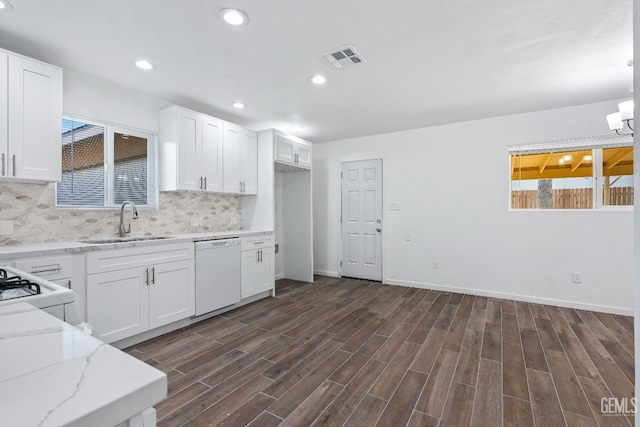 kitchen with white appliances, plenty of natural light, sink, and white cabinets