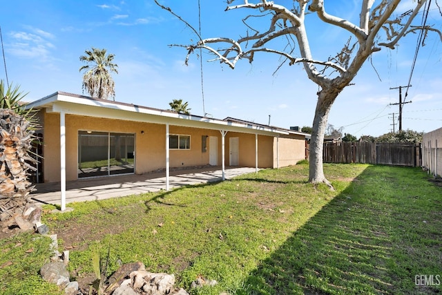 rear view of house featuring a yard and a patio area