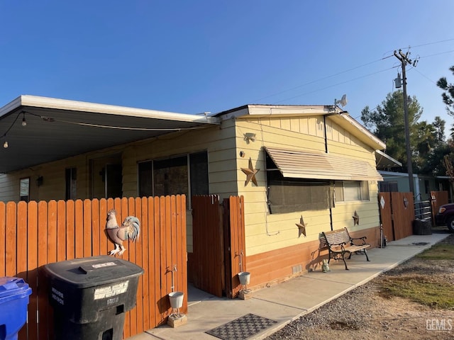 view of side of property with crawl space and fence