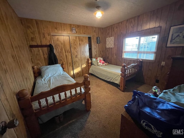 carpeted bedroom featuring a closet and wood walls