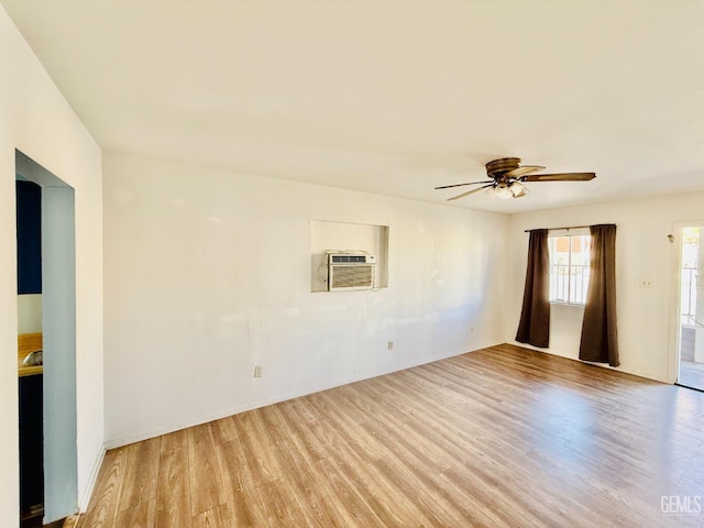 empty room featuring light wood-style flooring, ceiling fan, and a wall mounted air conditioner