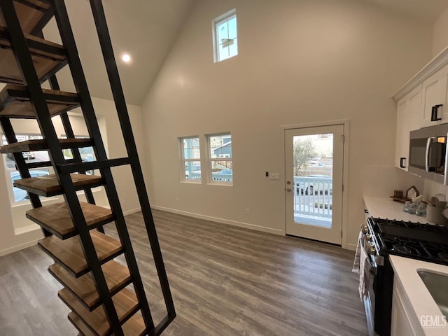5929 Gran Paseo Way, Atascadero, CA 93422 - stairway featuring high vaulted ceiling, baseboards, a healthy amount of sunlight, and wood finished floors