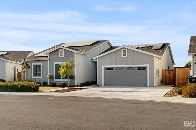 view of front of property featuring an attached garage, driveway, board and batten siding, and solar panels