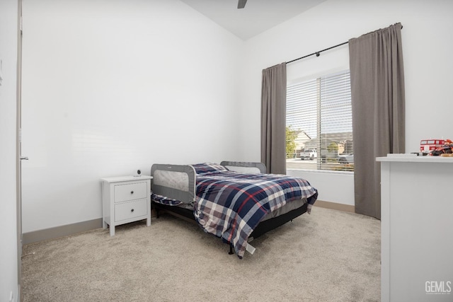 bedroom featuring baseboards, ceiling fan, and light colored carpet