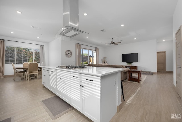 kitchen featuring light countertops, a center island, white cabinets, and stainless steel gas cooktop