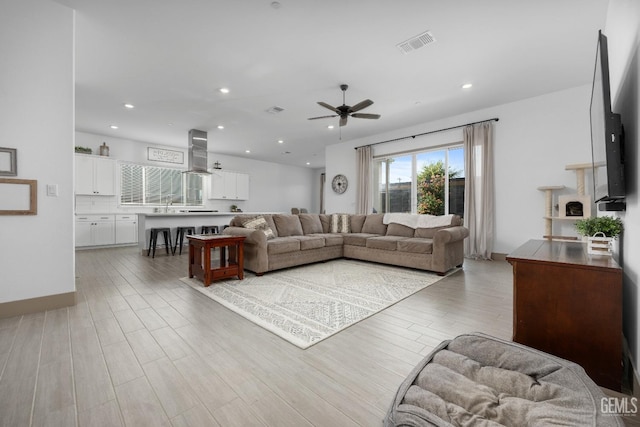 living area featuring a ceiling fan, recessed lighting, visible vents, and wood finished floors