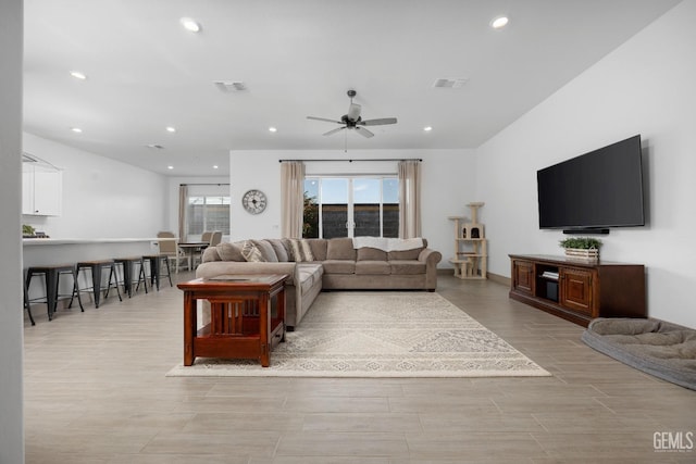 living room with a ceiling fan, light wood-style flooring, visible vents, and recessed lighting