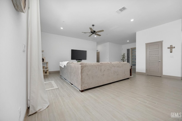 living room featuring light wood-style floors, recessed lighting, visible vents, and a ceiling fan