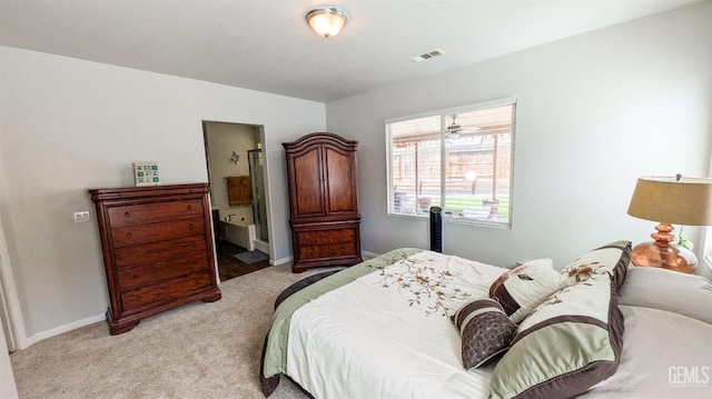 bedroom featuring visible vents, light colored carpet, and baseboards