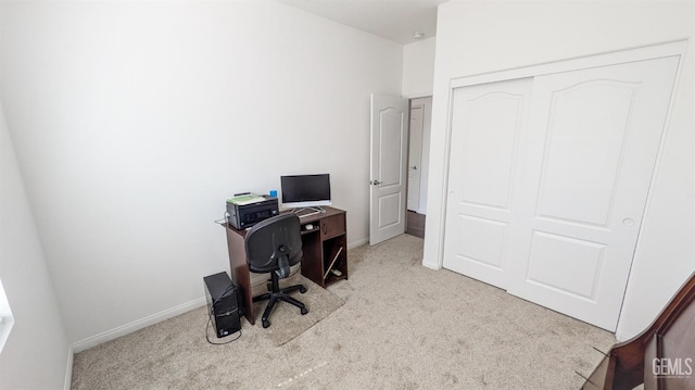 carpeted office featuring baseboards