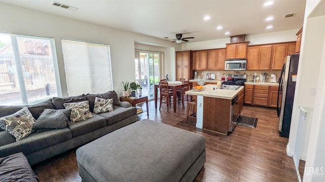living area featuring dark wood-style flooring, visible vents, ceiling fan, and recessed lighting