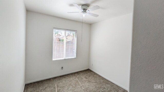 spare room featuring carpet floors, baseboards, and a ceiling fan