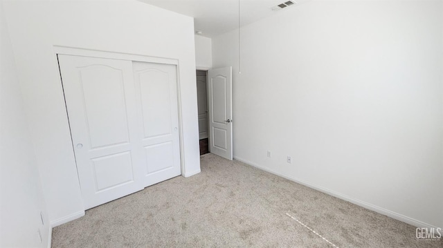 unfurnished bedroom featuring visible vents, baseboards, carpet flooring, and a closet