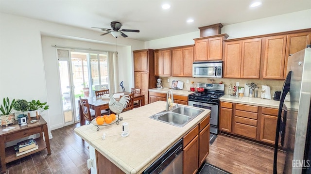 kitchen featuring a sink, ceiling fan, tile countertops, and stainless steel appliances