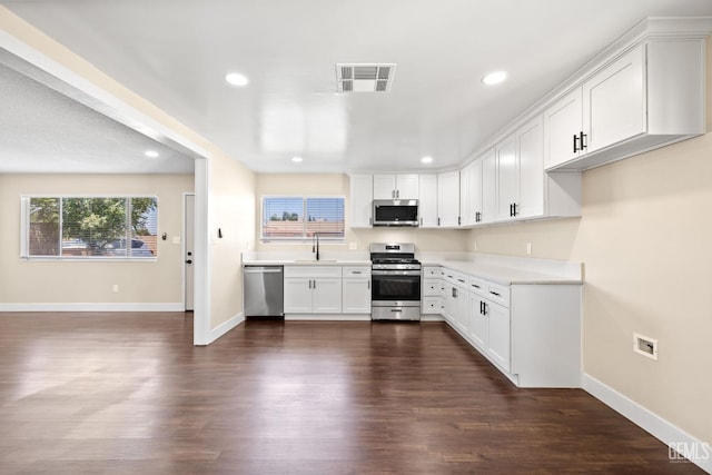 2605 Bladen St, Bakersfield, CA 93309 - kitchen with appliances with stainless steel finishes, recessed lighting, dark wood finished floors, white cabinets, and light countertops