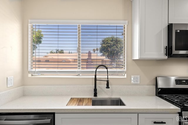 2605 Bladen St, Bakersfield, CA 93309 - kitchen with appliances with stainless steel finishes, white cabinets, and light stone countertops